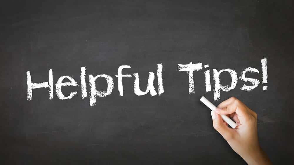 A hand writing Helpful Tips on a chalkboard