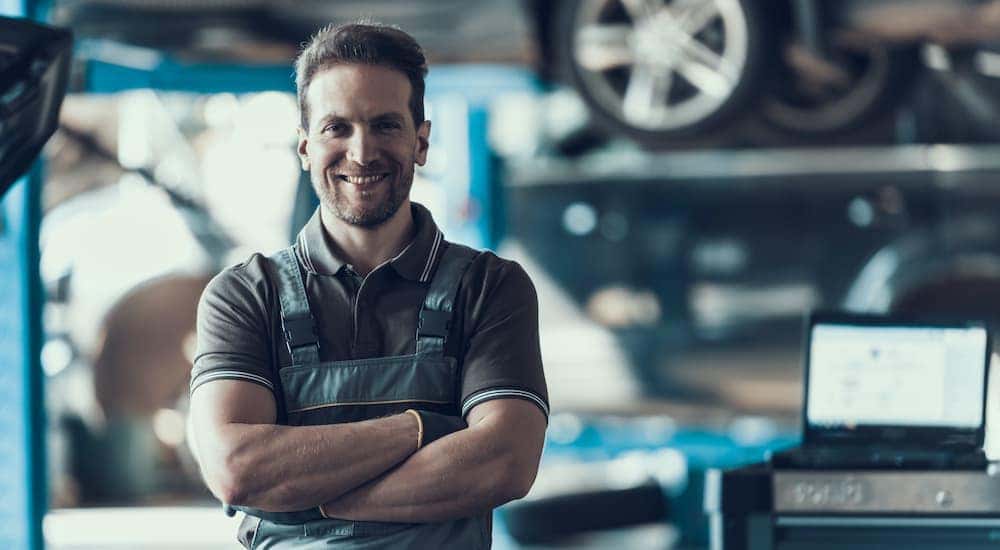 A mechanic is standing in a shop helping a customer with Chevy truck parts.