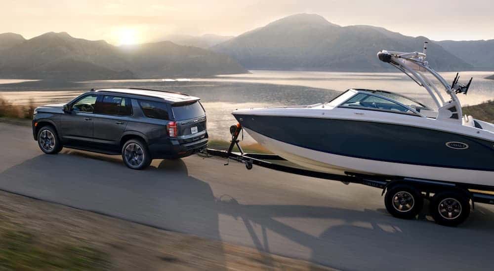 A gray 2021 Chevy Tahoe towing a boat.