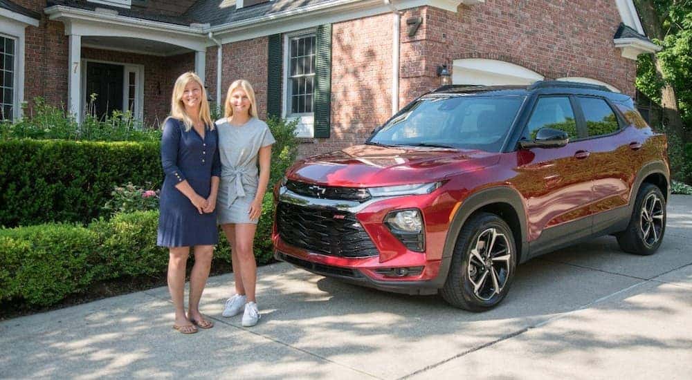 A mom and daughter are in a driveway next to a red 2021 Chevy Trailblazer after leaving a Chevy dealer in Ohio.