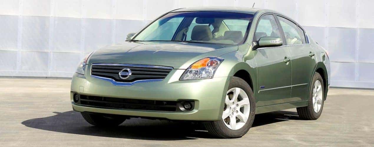 A green 2007 used Nissan Altima is shown on concrete.