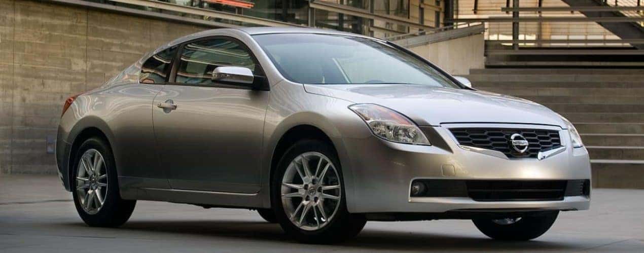 A silver 2008 used Nissan Altima is shown parked near stairs.