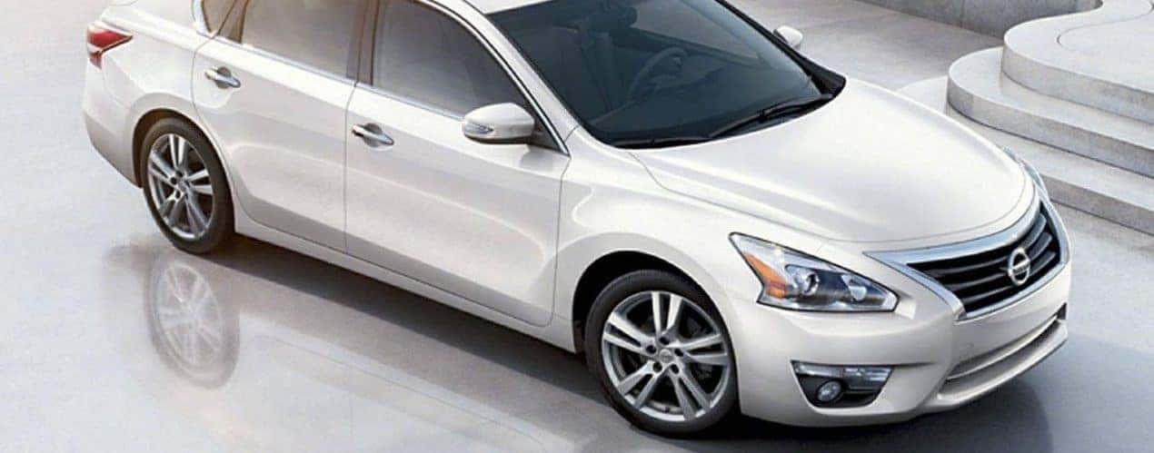 A white 2014 used Nissan Altima is shown from from above in front of marble stairs.