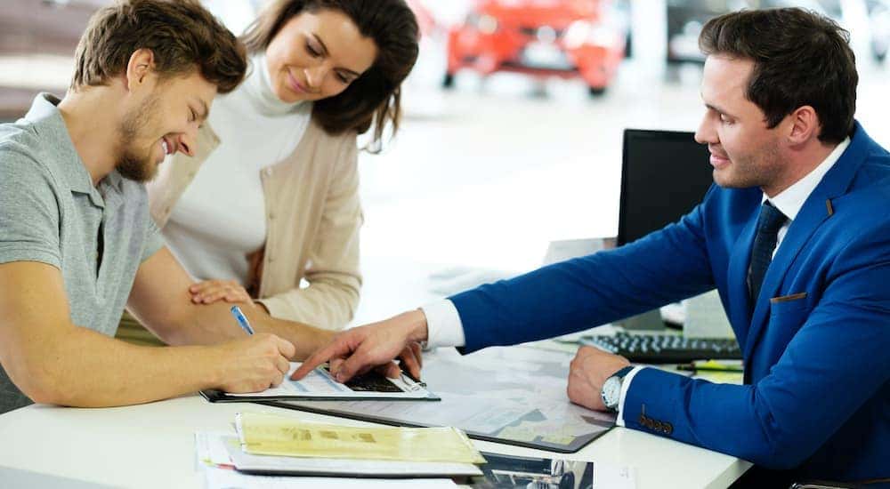 A couple is shown discussing their trade-in value with a sales person.