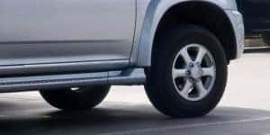 A closeup is shown of the tire on a silver SUV.