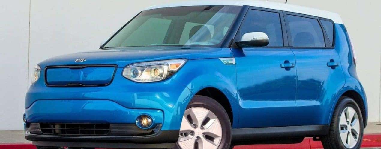 A blue 2015 used Kia Soul is shown in front of a white wall.