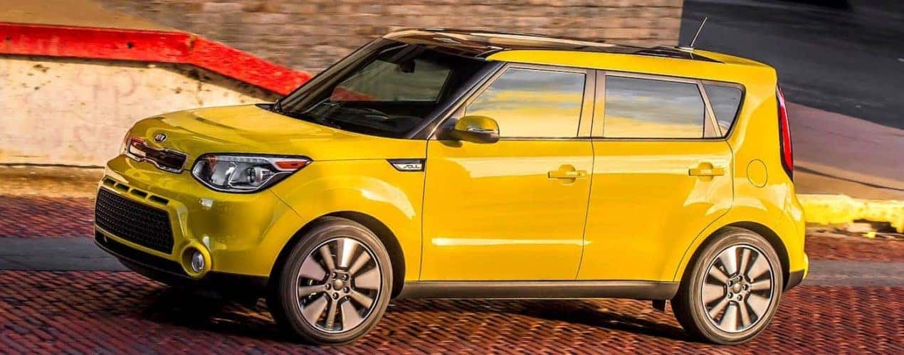 A yellow 2016 used Kia Soul is on a brick road.