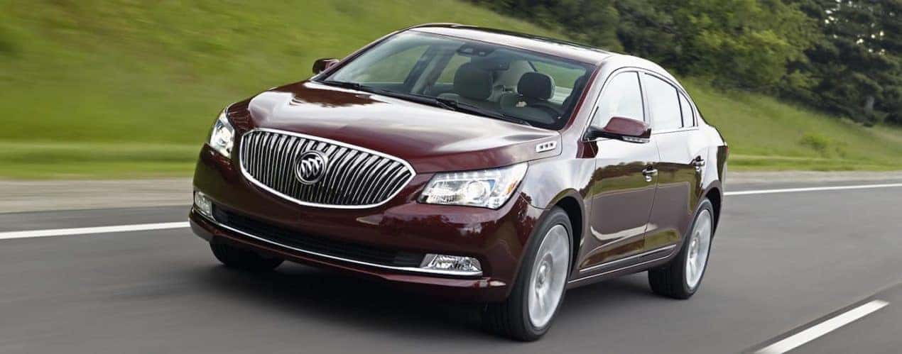 A burgundy 2016 used Buick LaCrosse is shown driving on grassy road.