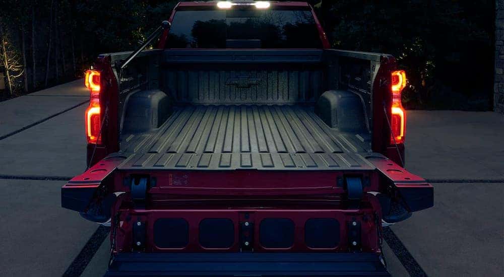 The truck bed liner of a red 2023 Chevy Silverado 1500 is shown at night.