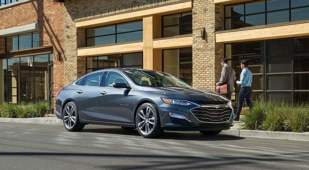 A grey 2020 Chevy Malibu is shown parked on the side of a street after viewing used cars in Cincinnati.
