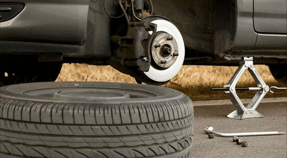A tire getting changed on a chevy car