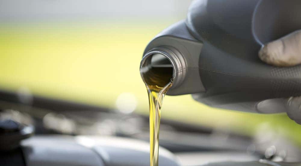 Soft focus bottle of oil being poured into car