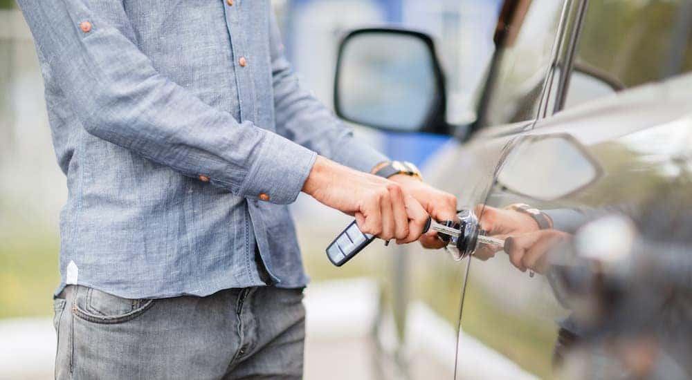 A person is shown unlocking a car.