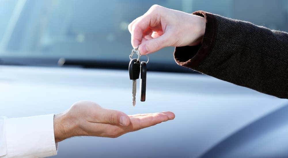 Hands are shown exchanging keys at a Buy Here Pay Here in Lexington.