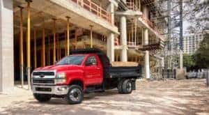A bight red Chevy commercial truck with black dump body is parked at a job site in Cincinnati.