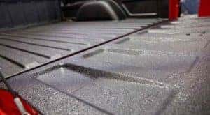A closeup is shown of a black spray on truck bed liner from McCluskey Chevy in Cincinnati, OH.