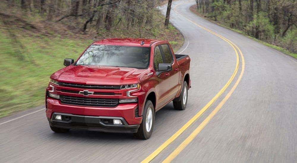 A rede 2019 Chevy Silverado travels a quiet country road