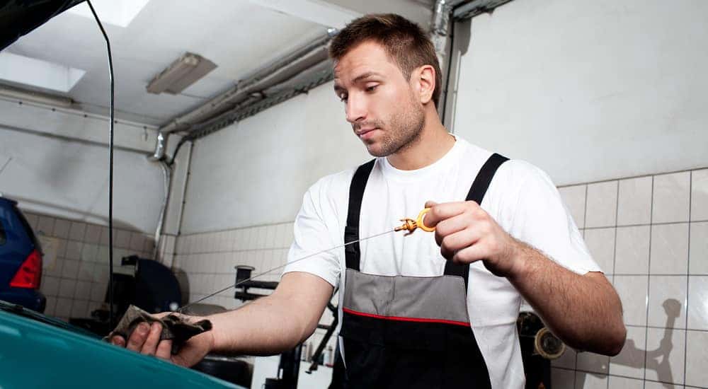 A technician checks the oil level after performing a oil change on a car