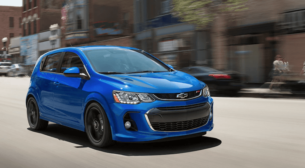 A blue 2019 Chevy Sonic drives a empty Dayton Ohio street