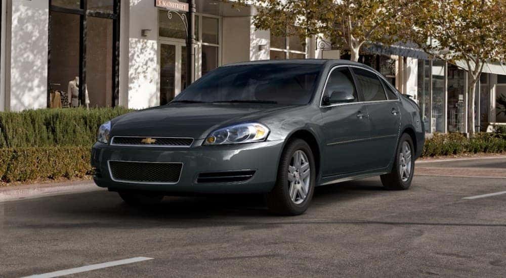 A gray 2013 Chevy Impala parked on a city street