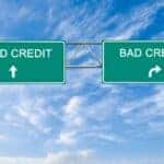 Highway signs against a cloudy blue sky reading Good Credit ahead and Bad Credit to the right are shown.