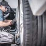A mechanic inspects a used car