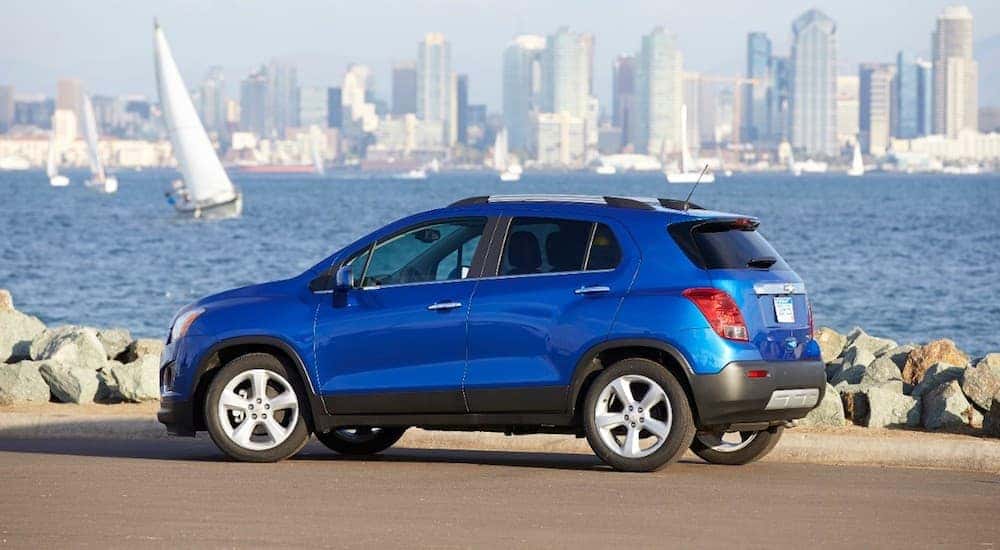 A blue 2015 Chevy Trax with a city in the back