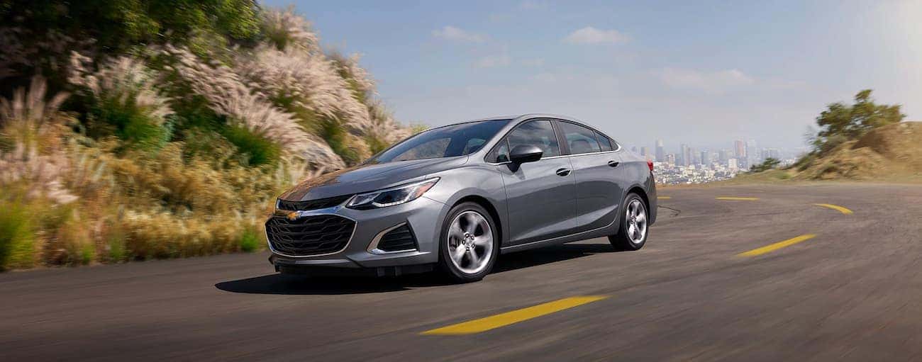 A gray 2019 Chevy Cruze driving away from a city