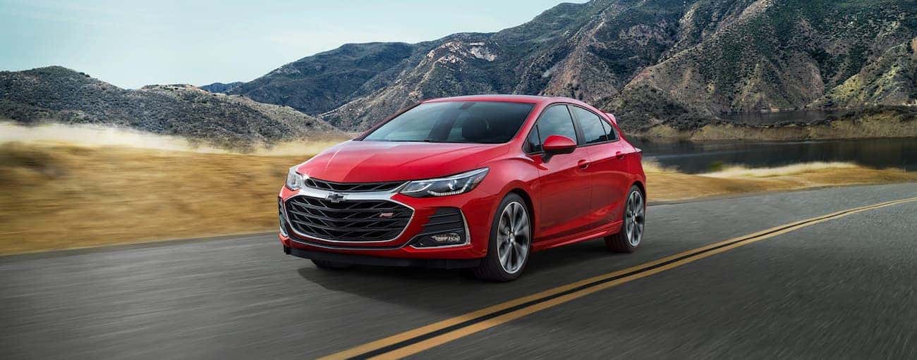 A red 2019 Chevy Cruze hatchback driving along a mountain road