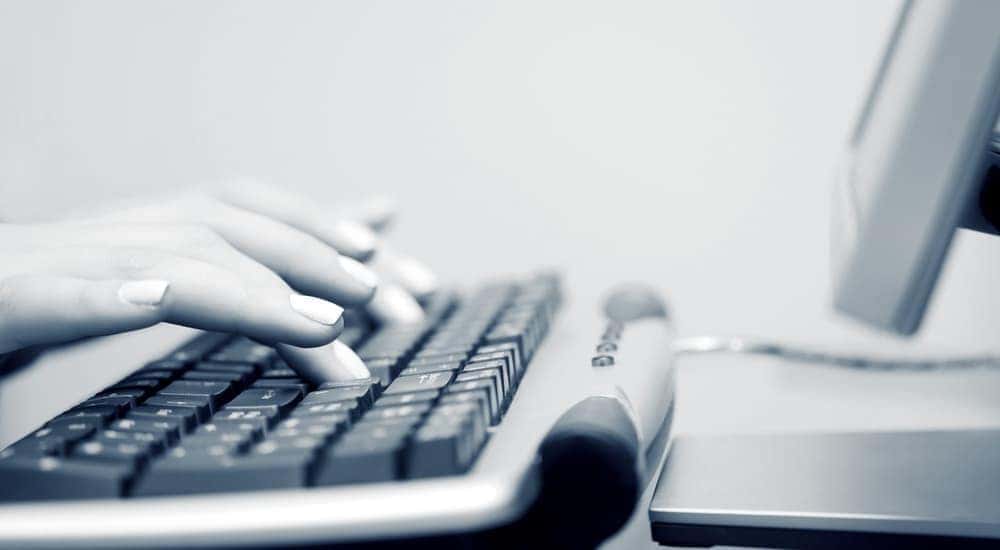 A black and white picture of hands on a keyboard is shown when searching for a Buy Here Pay Here in Lexington.