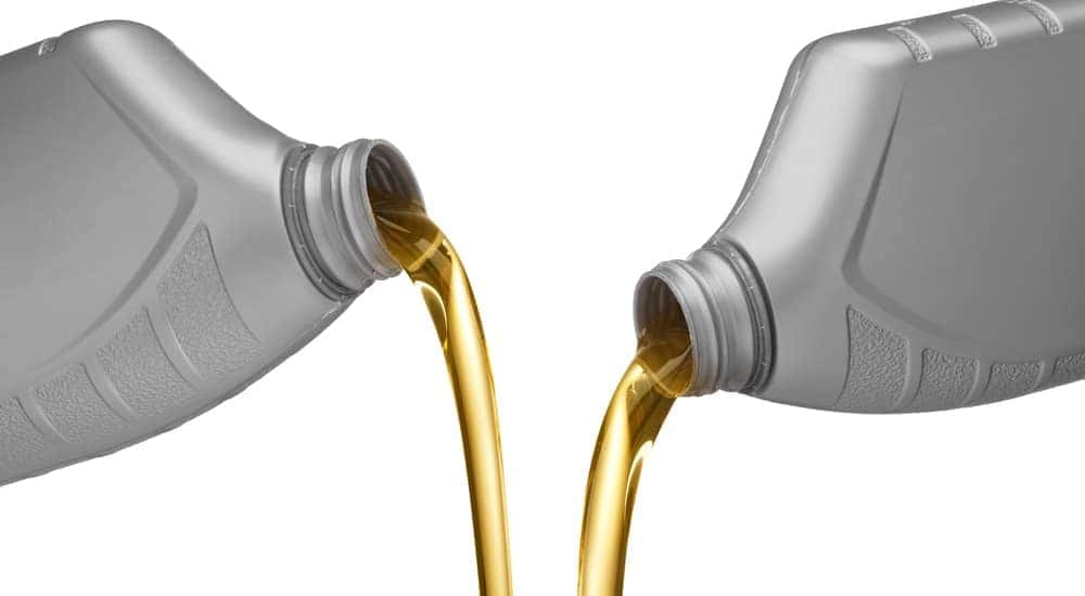 Fresh oil being poured from bottles at a local auto dealer