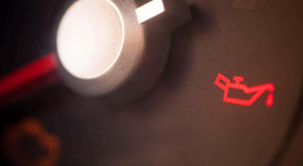 An oil light is lit up on a zoomed in dash.