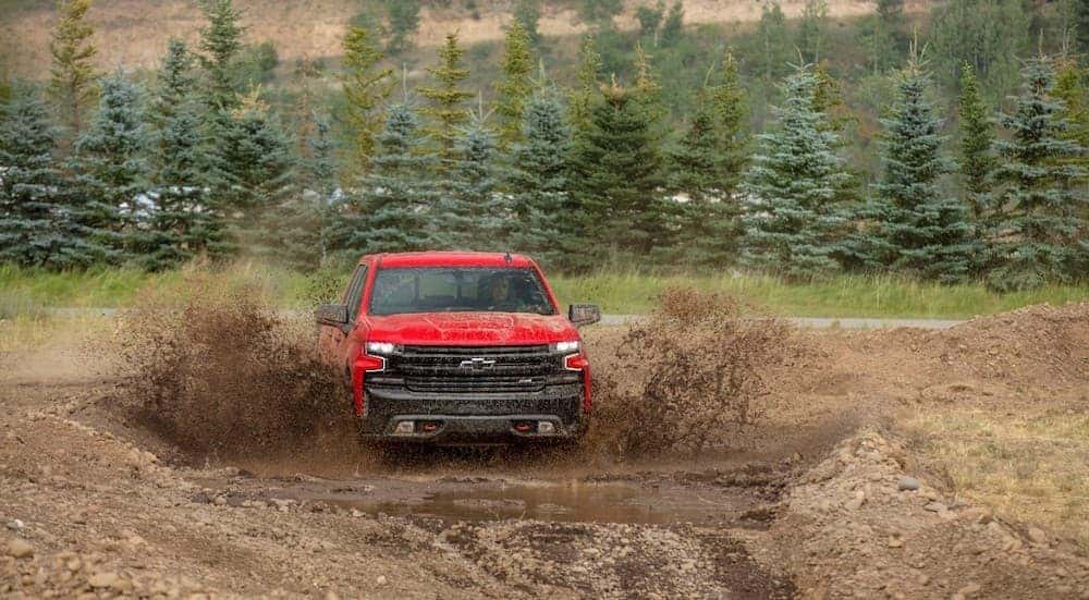 A red 2019 Chevy Silverado TrailBoss is driving through a mud pit far from home in Cincinnati, OH.