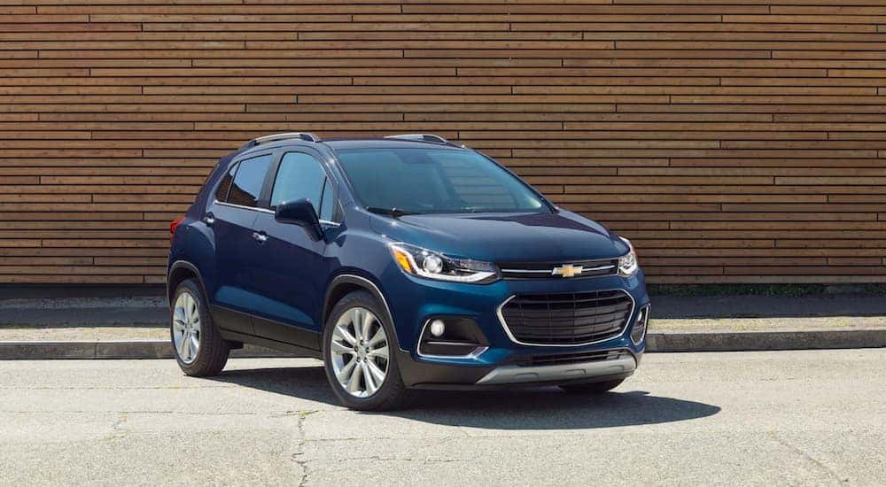A blue 2019 Chevy Trax is parked outside of a wood sided building in Cincinnati, OH.