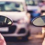 Mirrors of two cars are shown with more vehicles at a buy here, pay here in Cincinnati, OH.
