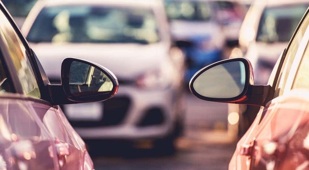 Mirrors of two cars are shown with more vehicles at a buy here, pay here in Cincinnati, OH.