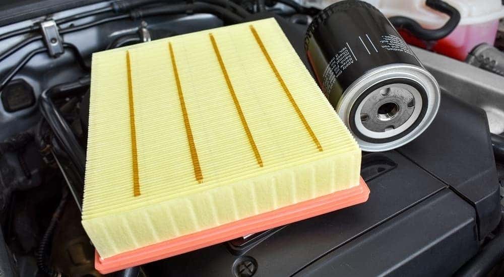 An oil filter and an air filter are sitting on a motor bay during and oil change in Cincinnati, OH.