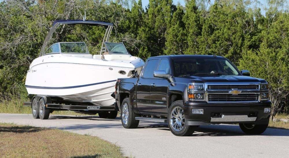 A black Chevy Silverado is towing a boat near Louisville.