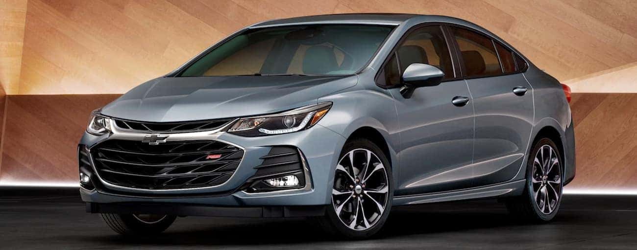 A grey 2019 Chevy Cruze is parked in front of a wood wall near Cincinnati, OH.