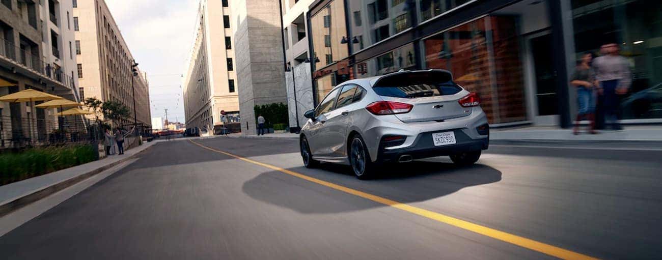 A grey 2019 Chevy Cruze hatchback is driving through the city.