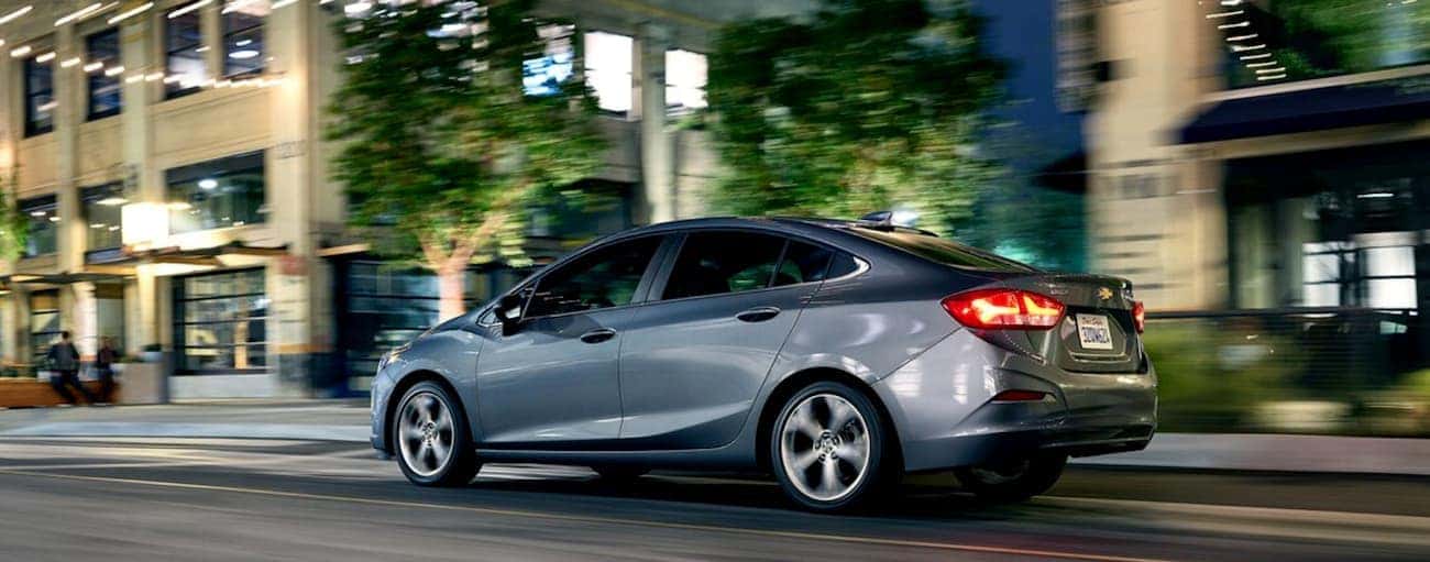 A grey 2019 Chevy Cruze is driving through Cincinnati, OH at night.