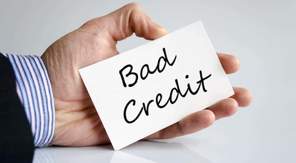 'Bad Credit' is written on a card in someone's hand.
