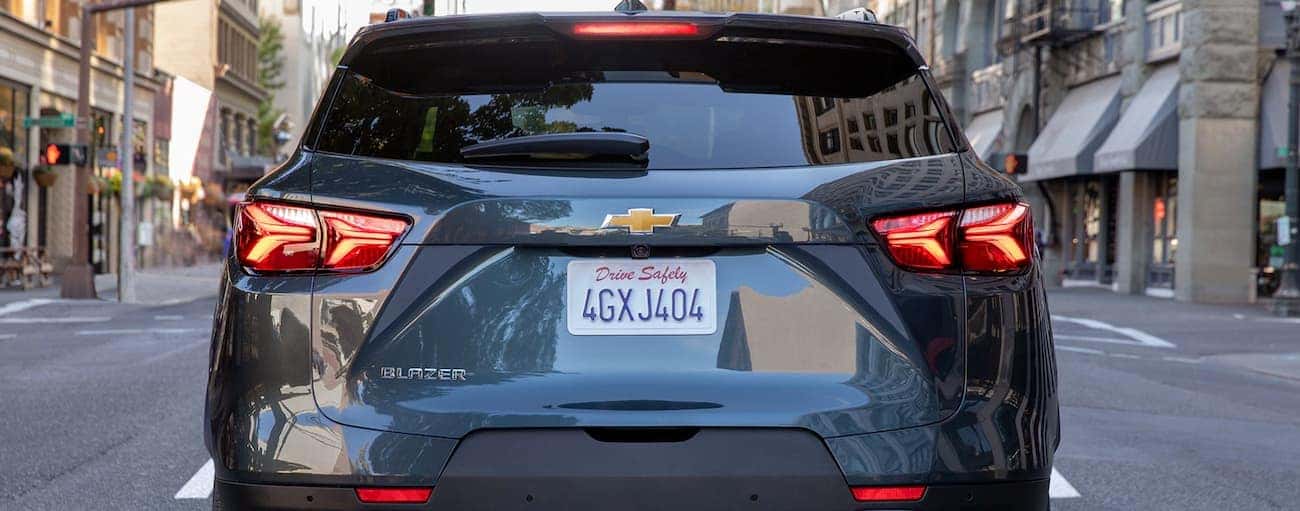 The rear end of a dark grey 2019 Chevy Blazer is shown on a city street.