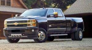 A black 2019 Chevy Silverado HD 3500 is shown parked near a building after viewing diesel trucks for sale.