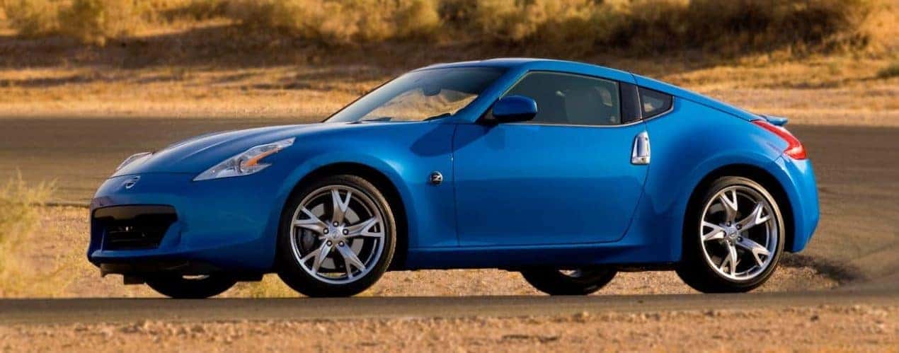 A blue 2009 used Nissan 370Z on a dirt track