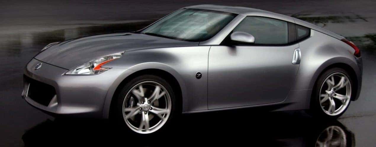 A silver 2011 Nissan 370Z is on a dark, wet road outside Cincinnati, OH.
