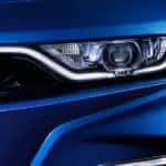 A close up of a blue 2020 Chevy Camaro front grill and headlight.