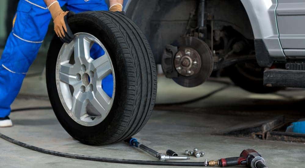 A mechanic is putting a tire on a used car in Columbus, OH.