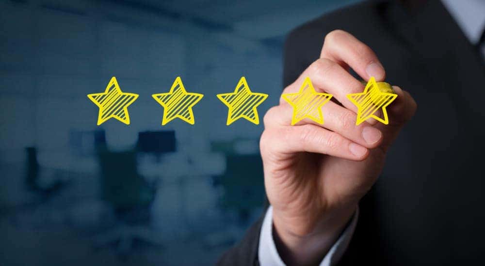 Five stars are being drawn on a clear board with a yellow marker. 