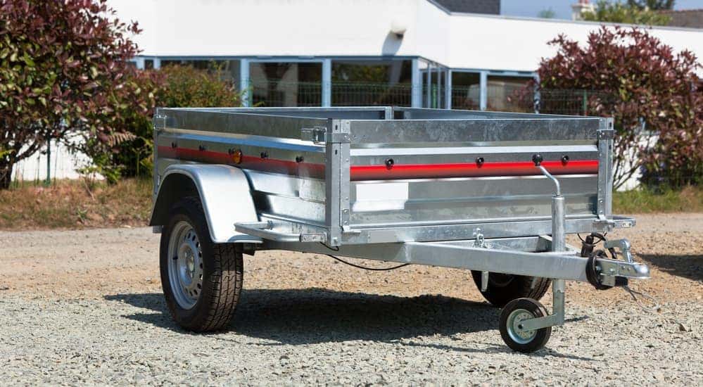 A standard size moving trailer is parked in front of an office building.